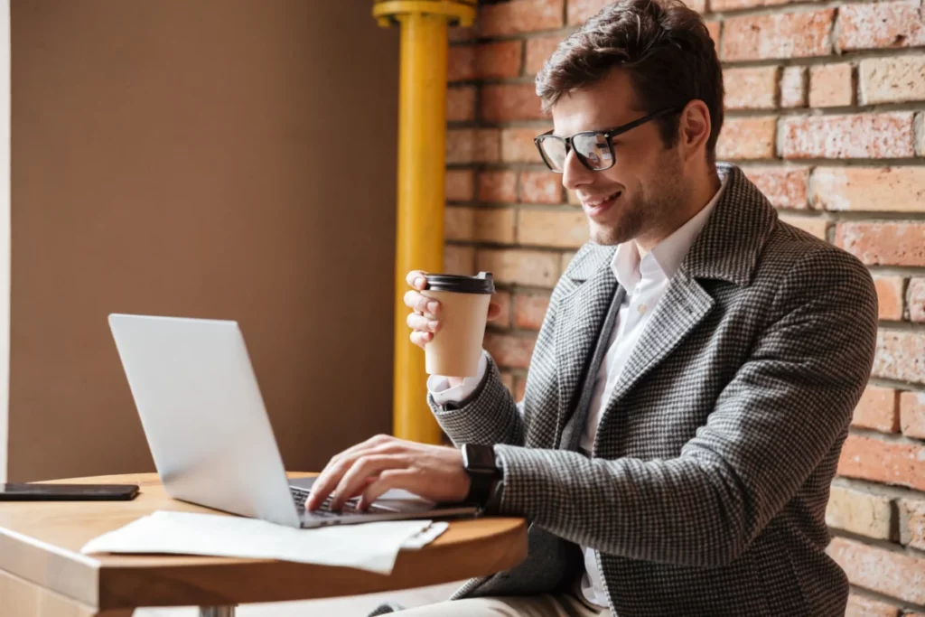 empresário de óculos bem vestido mexendo no notebook empreender com pouco dinheiro