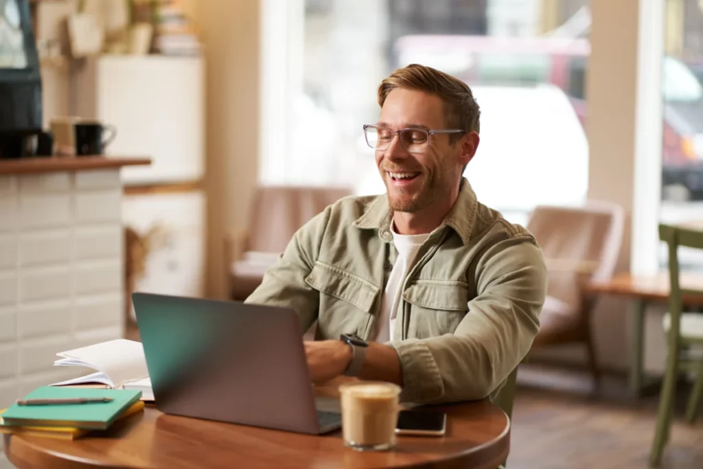 imagem-de-um-jovem-nomade-digital-de-oculos-sentado-em-um-cafe-trabalhando-em-uma-cafeteria-usando-um-laptop-nichos mais lucrativos