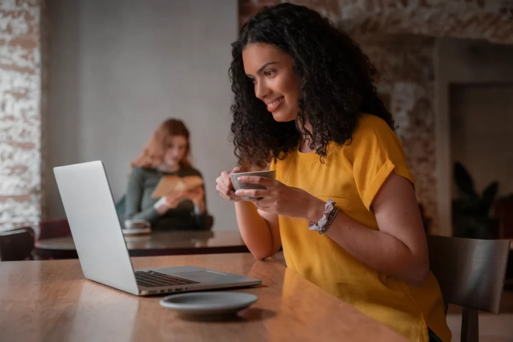 mulher com laptop em uma cafeteria como começar a vender na internet