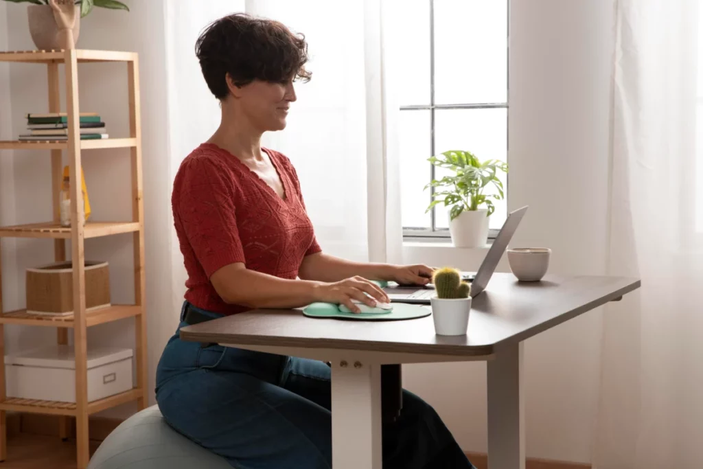 empreendedora feliz sentada em bola ergonômica enquanto trabalha no computador em casa - plataforma de venda online