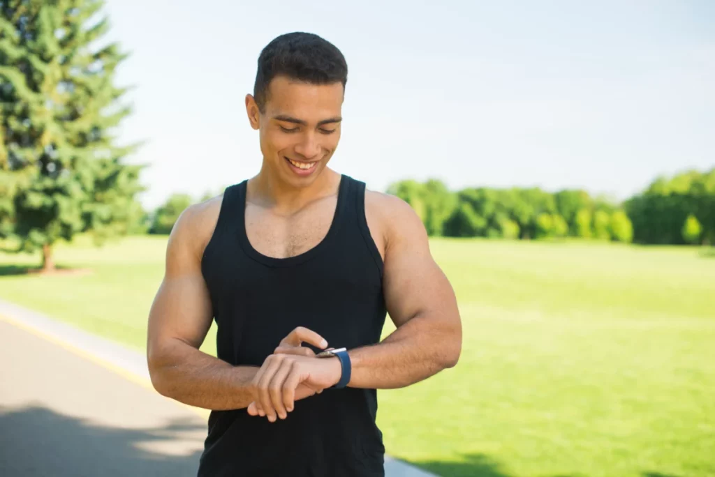 homem atleta mexendo no relógio esportivo - relógios masculinos esportivos mais vendidos