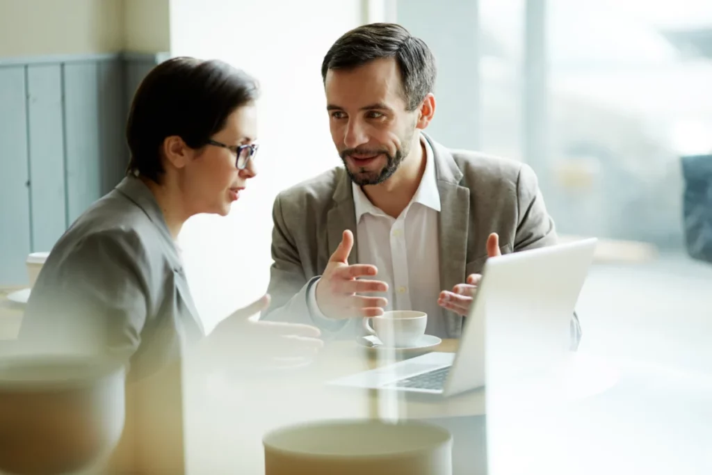 homem e mulher conversando sentados atrás de um notebook - o que é upsell