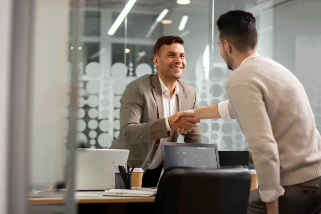 homens fazendo um aperto de mão em sala de escritório - o que é upsell