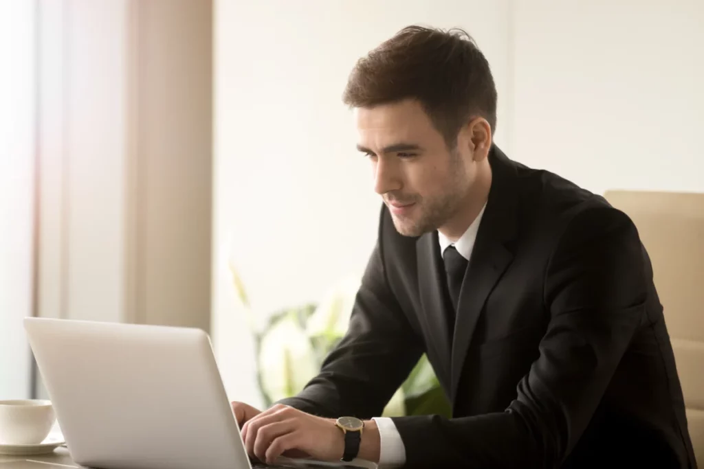 homem de negócios bem vestido mexendo no computador - curso de marketplace