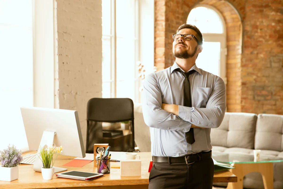 homem de negócios em pé e de braços cruzados em frente à mesa de trabalho - plataforma de marketplace