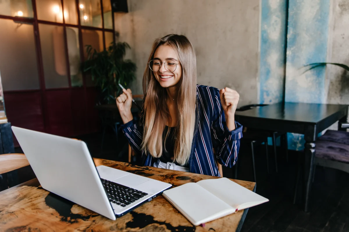 mulher empreendedora comemorando em frente ao notebook de trabalho - maiores marketplaces brasil