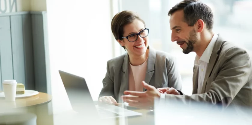 homem-e-mulher-bem-vestidos-em-empresa-conversando-atras-do-computador-gestao-ecommerce