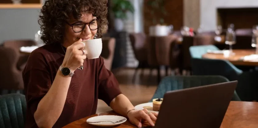 mulher tomando café enquanto trabalha de casa sentada no computador - produtos mais vendidos na shopee